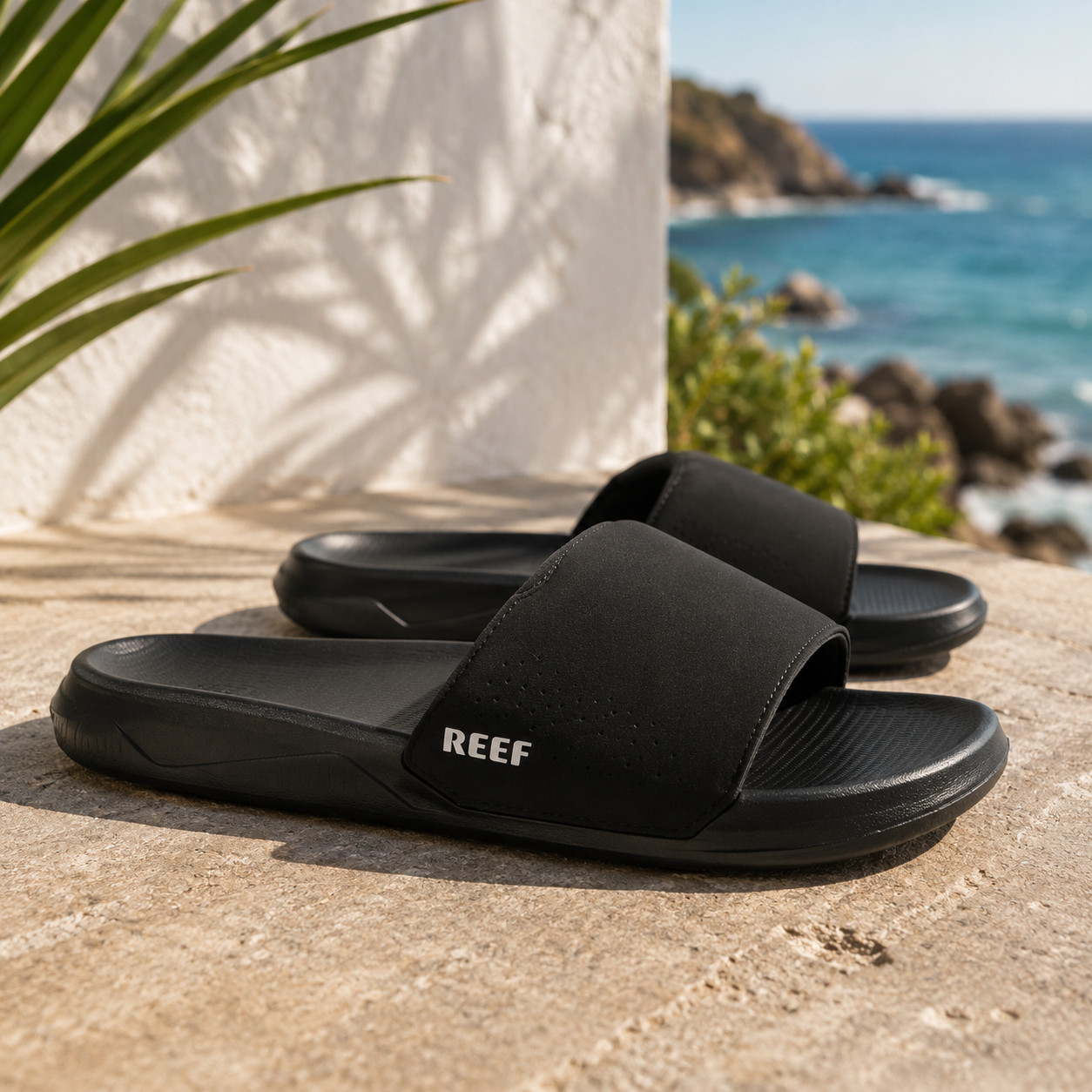 Chanclas pala Reef Tailslide Black para hombre sobre piedra junto al mar con estilo surf lifestyle premium y ambiente Costa del Sol