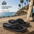 Chanclas Reef Cushion Bonzer Black Gum para hombre en fotografía editorial propia de THE SURF TOWN sobre carretera coastal California con estilo surf lifestyle premium