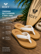 Chanclas Roxy Porto Natural para mujer en escena beach lifestyle premium sobre madera junto al mar tropical