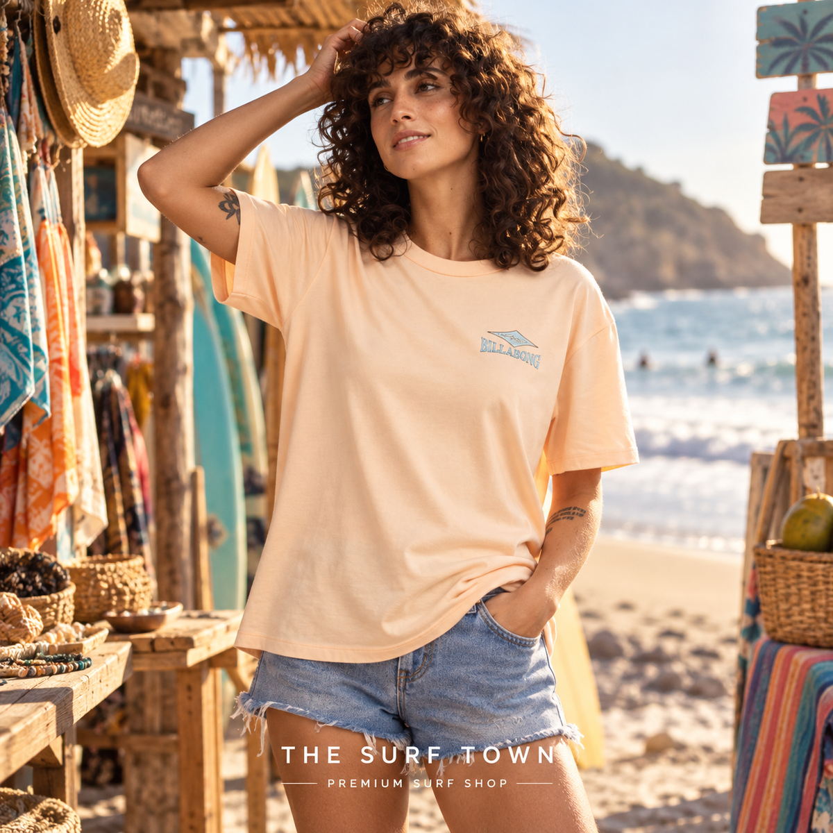 Camiseta Billabong Heritage Baker - Melocotón (Soft Peach) en una escena lifestyle junto al mar; imagen editorial propia de THE SURF TOWN