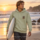 Sudadera Billabong Stamp - Verde (Vintage Green) en una escena lifestyle junto al mar; imagen editorial propia de THE SURF TOWN