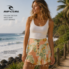 Falda Rip Curl Follow The Sun Walk Light Orange en fotografía editorial propia de THE SURF TOWN junto a olas y sendero costero en surf lifestyle tropical premium
