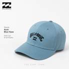 Gorra Billabong Arch Blue Haze en fotografía editorial propia de THE SURF TOWN con bordado frontal negro, diseño surf clásico y acabado premium sobre fondo limpio tipo catálogo de moda surf.