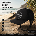 Gorra Dakine Surf Trucker Black en fotografía editorial propia de THE SURF TOWN sobre playa surfera con tabla de surf y ambiente coastal premium