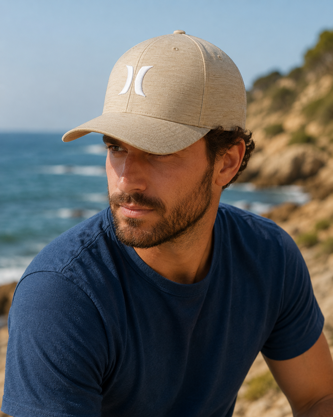 Gorra Hurley beige H2O Dri estilo surf lifestyle en entorno de costa mediterránea para hombre