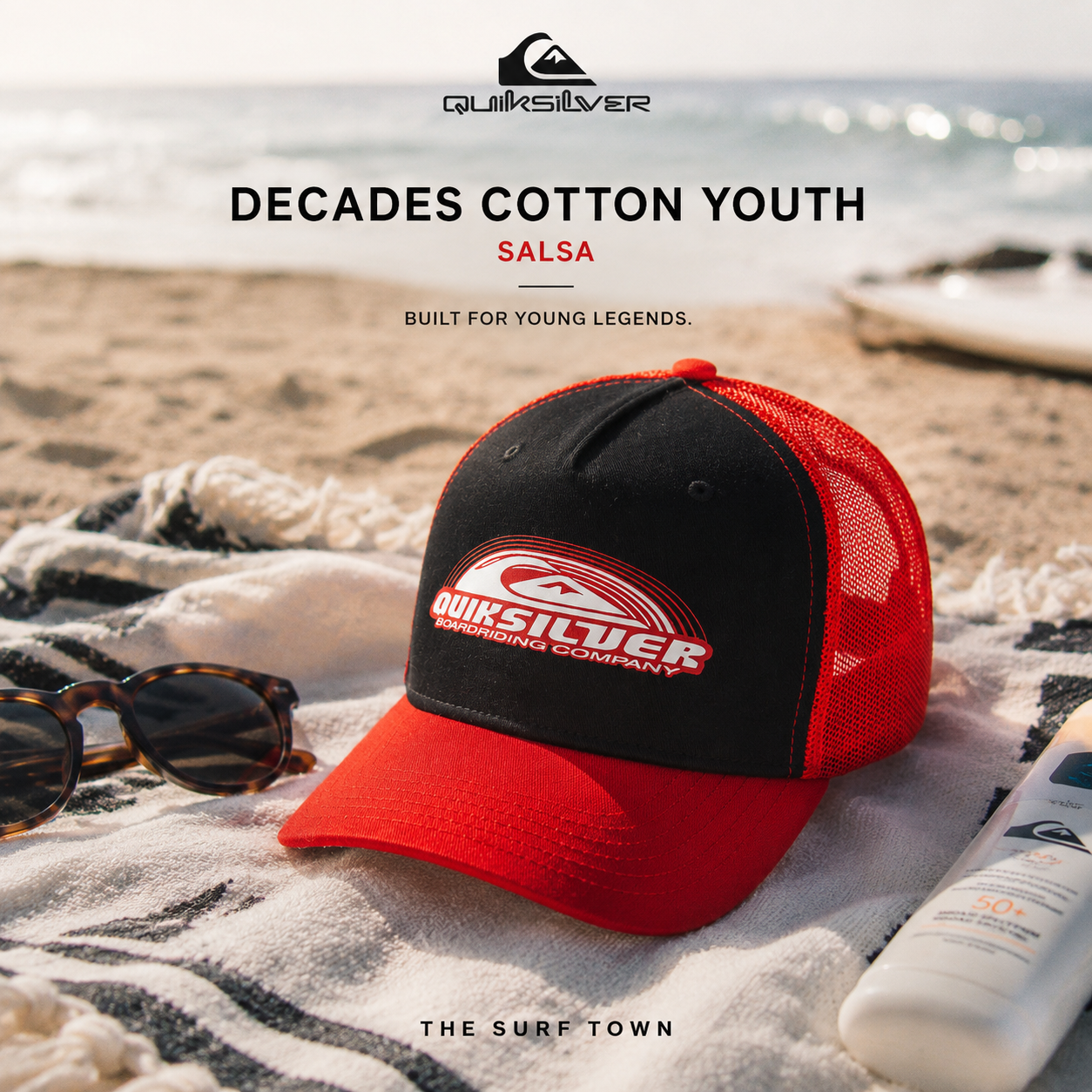 Gorra Quiksilver Decades Cotton Youth Salsa en fotografía editorial propia de THE SURF TOWN sobre toalla de playa junto al mar, estilo surf lifestyle de vacaciones y verano.