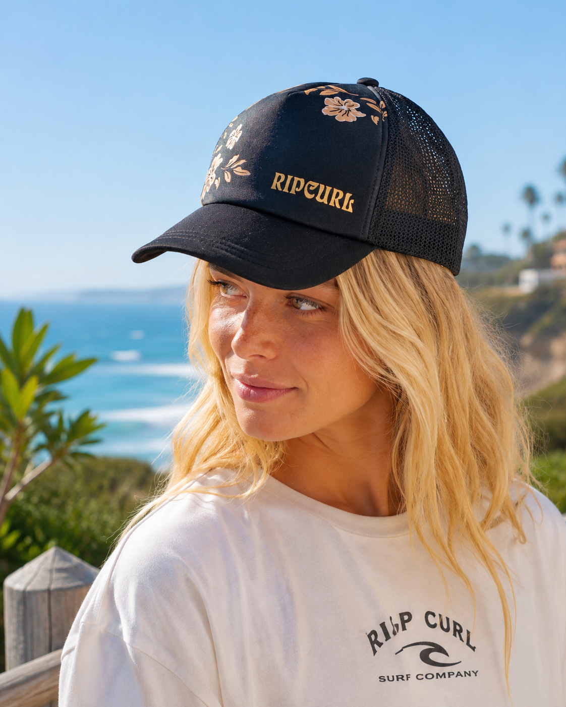 Gorra Rip Curl Trucker Mixed Black en acantilados junto al mar con estética surf lifestyle femenina premium
