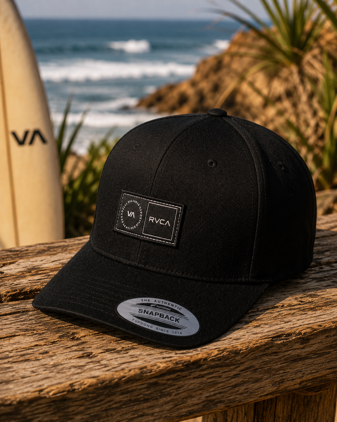 Gorra RVCA Platform negra estilo surf lifestyle sobre mesa de madera junto al mar
