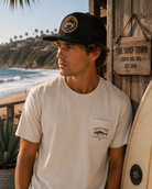 Gorra Salty Crew Jimmy Trucker Black en ambiente surf lifestyle junto a la playa con estilo Costa del Sol y beach vibes premium