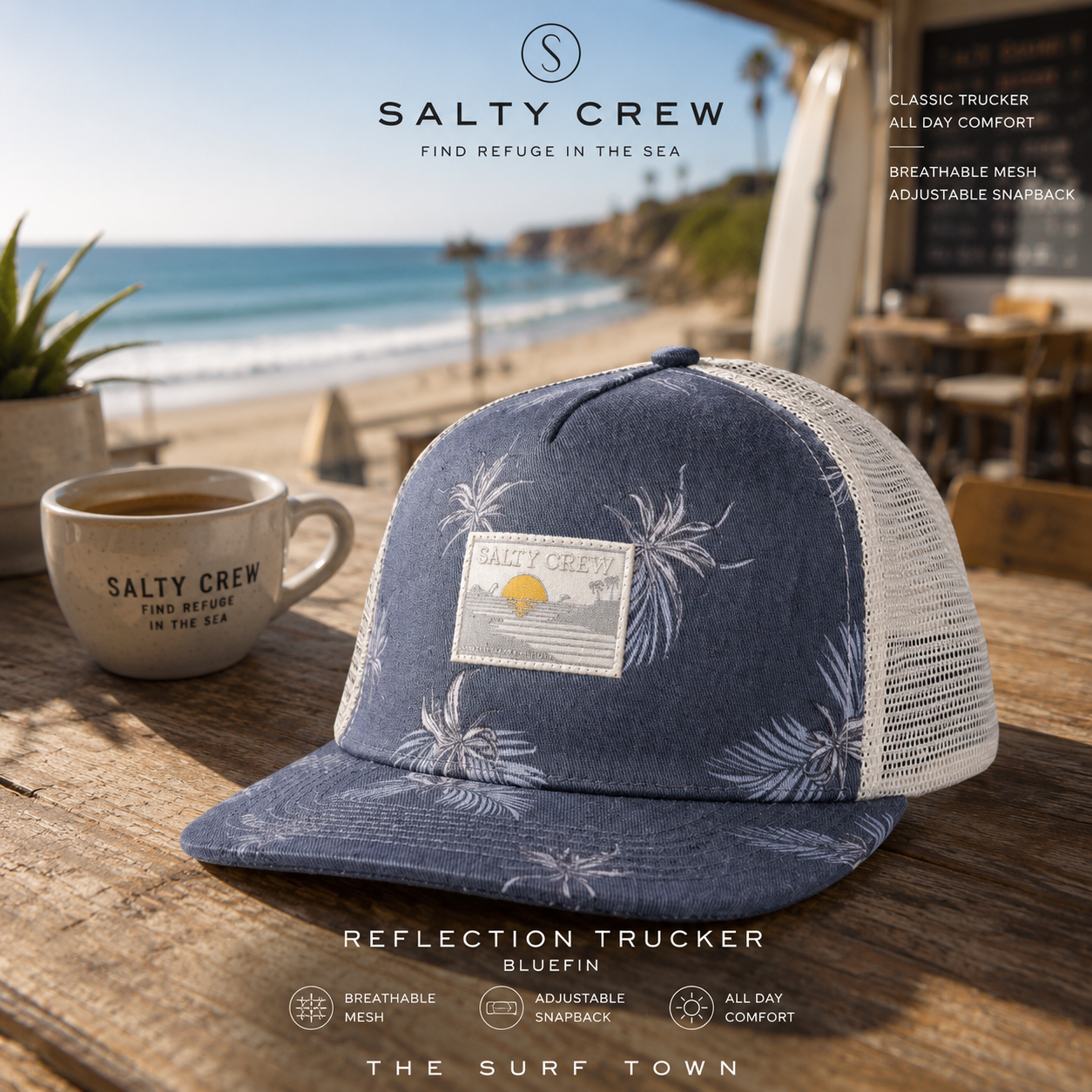 Gorra Salty Crew Reflection Trucker Bluefin en café surf premium junto a la playa, fotografía editorial propia de THE SURF TOWN con diseño trucker azul, rejilla transpirable y estilo surf lifestyle