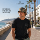 Gorra Salty Crew Steadfast Retro Trucker Camo en paseo marítimo de la Costa del Sol, fotografía editorial propia de THE SURF TOWN con estilo surf lifestyle y diseño trucker camuflaje