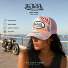 Mujer con Gorra Von Dutch Bra Pink en una imagen editorial propia de THE SURF TOWN de estética café racer.