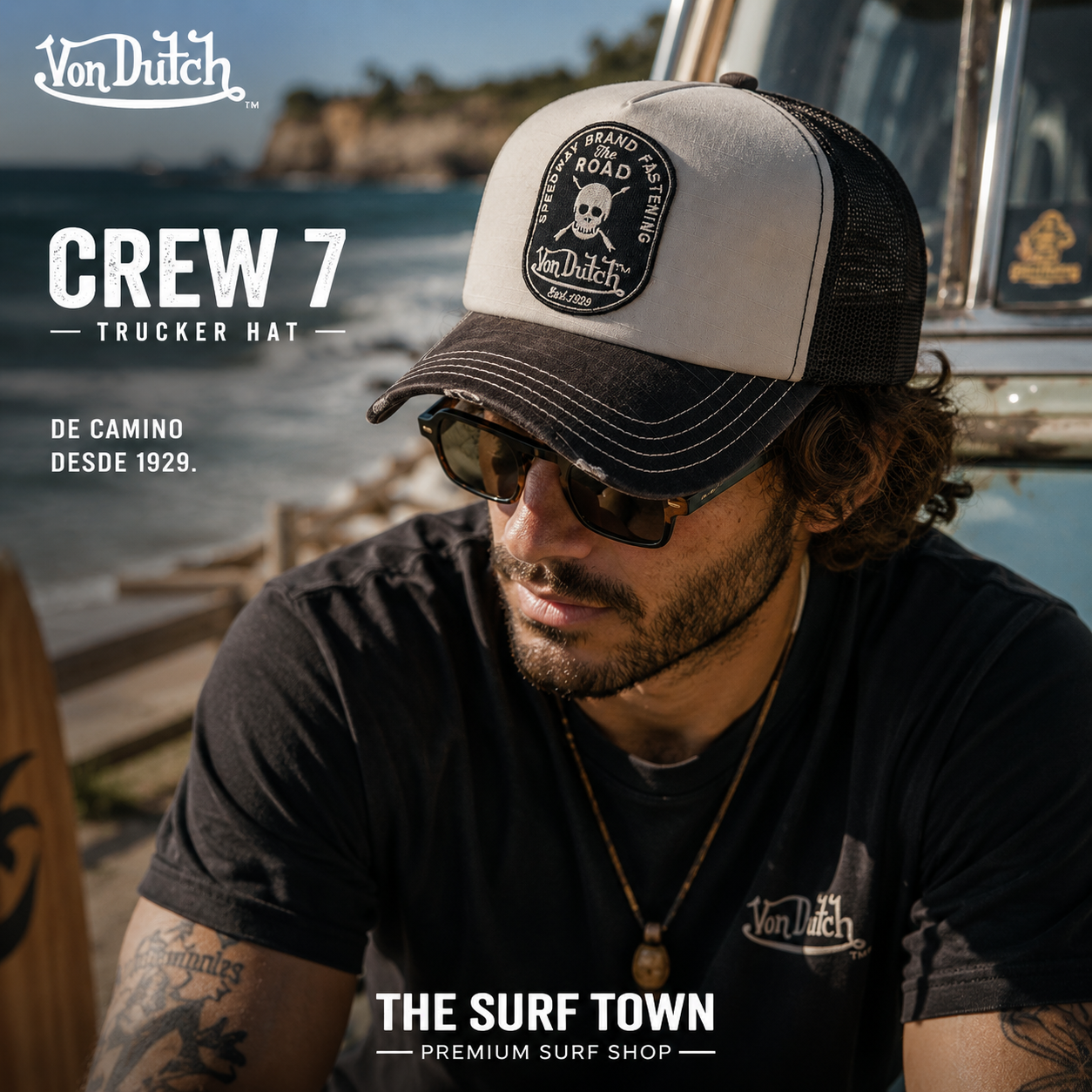Gorra Von Dutch Crew 7 estilo trucker en negro y beige con parche frontal, en escena lifestyle costera de THE SURF TOWN
