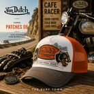 Gorra Von Dutch Patches 06 en fotografía editorial propia de THE SURF TOWN en ambiente cafe racer junto a moto clásica y carretera costera, gorra trucker vintage con parches bordados y estilo motero americano.