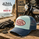 Gorra Von Dutch Used 01 en fotografía editorial propia de THE SURF TOWN en ambiente cafe racer junto a moto clásica y carretera costera, estilo vintage California road trip con inspiración motera americana.