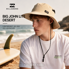 Gorro Billabong Big John Lite Desert en fotografía editorial propia de THE SURF TOWN junto al mar, sombrero surfero de aventura con cordón ajustable y protección solar para playa y vacaciones.