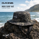 Gorro Dakine Indo Surf Hat Cascade Camo en fotografía editorial propia de THE SURF TOWN sobre roca volcánica frente al mar con protección solar para surf y estilo outdoor premium