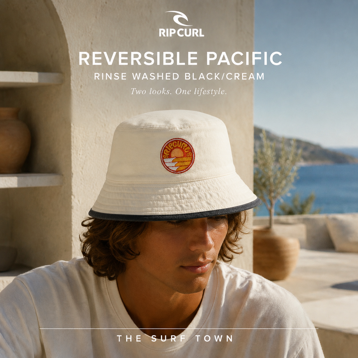 Gorro Rip Curl Reversible Pacific Rinse Washed Black Cream en fotografía editorial propia de THE SURF TOWN sobre terraza mediterránea premium frente al mar, diseño reversible para surf, playa y estilo outdoor con protección solar y look coastal lifestyle.