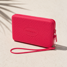 Bolsito Havaianas Mini Bag Pink Fever rosa sobre superficie mediterránea minimalista con sombras tropicales en ambiente beach lifestyle premium