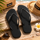 Chanclas Havaianas Slim Glitter II negras para mujer en escenario playa mediterránea lifestyle premium
