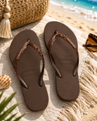 Chanclas Havaianas Slim Glitter II marrones para mujer en escenario playa boho mediterránea premium