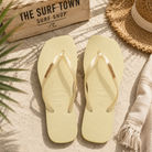 Chanclas Havaianas Slim Square Logo Metallic beige para mujer en escenario verano mediterráneo premium