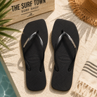 Chanclas Havaianas Slim Square Logo Metallic negras para mujer en escenario beach club surf premium