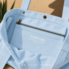 Interior del bolso The Surf Town Tote Beach Bag Blue Sky con bolsillo interior con cremallera y acabados premium, imagen exclusiva creada por THE SURF TOWN mostrando la capacidad y funcionalidad del bolso de playa de algodón azul cielo premium