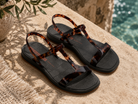 Sandalias Ipanema Glow Trendy negras con acabado turtle en terraza mediterránea coastal luxury