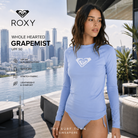 Fotografía propia de THE SURF TOWN de la licra Roxy Whole Hearted Grapemist para mujer en un rooftop de Singapur con skyline urbano premium y ambiente surf lifestyle contemporáneo.