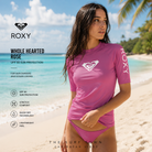 Fotografía propia de THE SURF TOWN de la licra Roxy Whole Hearted Rose UPF 50 para mujer en una playa caribeña de arena blanca y aguas turquesa con ambiente surf lifestyle premium.