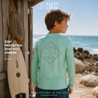 Licra Salty Crew Tippet Boys Sunshirt Mint para niño con protección solar en escenario surf lifestyle junto al mar