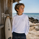 Licra Salty Crew Tippet Boys Sunshirt White para niño en escenario lifestyle surf con protección solar