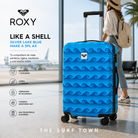 Maleta de Viaje Roxy Like A Shell Silver Lake Blue Make A Spl Ax en fotografía editorial propia de THE SURF TOWN con estilo travel lifestyle premium en aeropuerto moderno