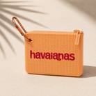 Monedero Havaianas Logomania Carabiner Peach color melocotón sobre superficie mediterránea minimalista con sombras tropicales en ambiente beach lifestyle premium