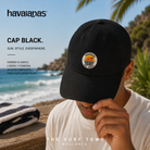 Gorra Havaianas Cap Black en fotografía editorial propia de THE SURF TOWN junto al mar con estilo beach lifestyle premium y luz natural diurna