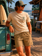 Pantalón híbrido Vissla No See Hums Dark Khaki en ambiente surf lifestyle junto al mar