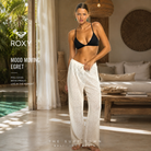 Fotografía propia de THE SURF TOWN del pantalón Roxy Mood Moving Egret para mujer en el interior de un hotel de lujo en Bali con materiales naturales, luz tropical y ambiente resort lifestyle premium.