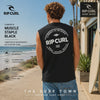 modelo llevando una Camiseta Rip Curl Muscle Staple Black durante un video editorial propio de the surf town en un paseo maritimo junto al mar con olas
