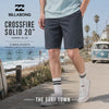surfero llevando unas Bermudas Billabong Hibrido Crossfire Solid 20 Ombre Blue durante un video propio promocional de the surf town en un paseo junto al mar