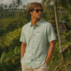 modelo vistiendo una Camisa Salty Crew SS Button Up Marine durante un video promocional de the surf town en bali