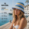 modelo llevando un Gorro Rip Curl Crochet Blue Natural durante una sesion de videos promocionales de the surf town en un puerto deportivo maritimo