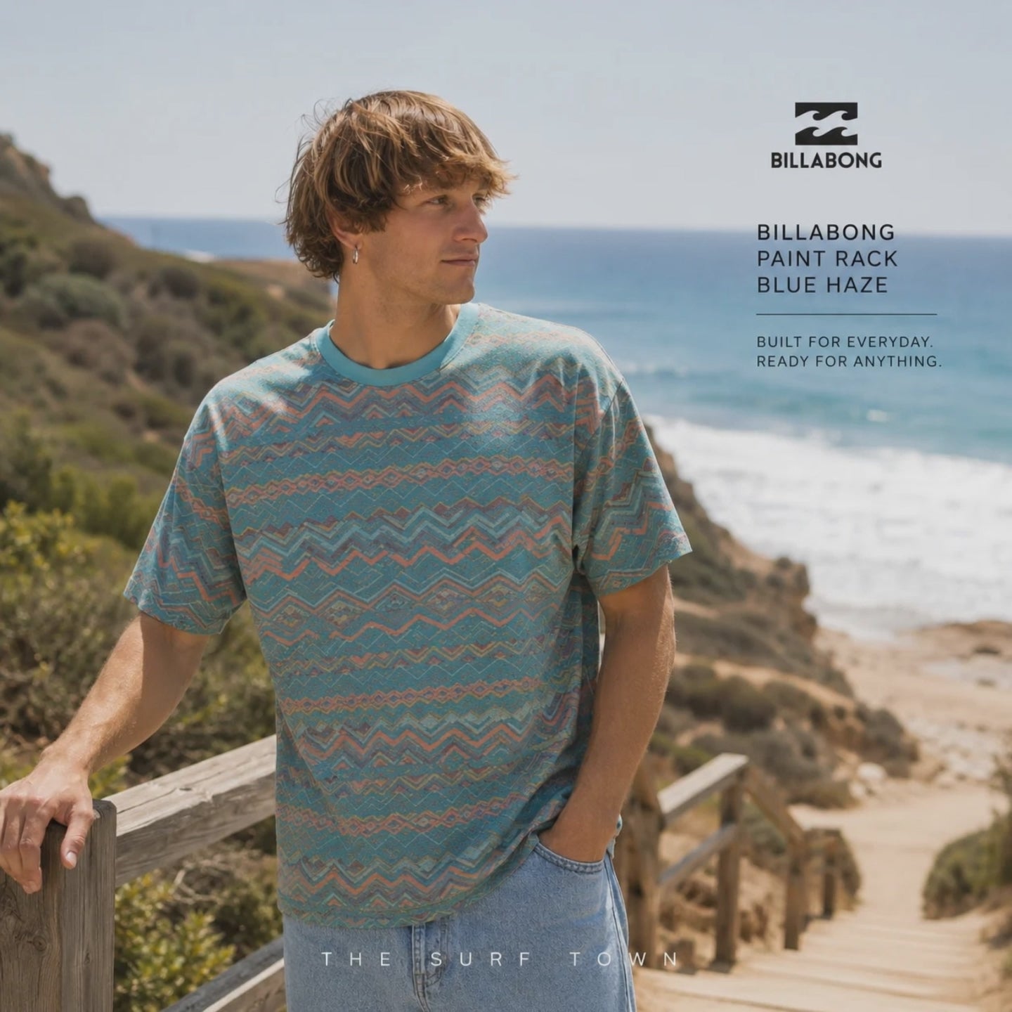 modelo vistiendo una Camiseta Billabong Paint Rack Blue Haze en un video promocional de the surf town en una pasarela de madera junto al mar