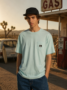 Camiseta Quiksilver Salt Water Pocket Blue Haze hombre estilo surf cinema aesthetic en gasolinera retro del desierto