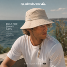 Sombrero Quiksilver Foxford Bucket color beige en entorno costero mediterráneo, fotografía editorial propia de THE SURF TOWN inspirada en el surf lifestyle y la protección solar al aire libre