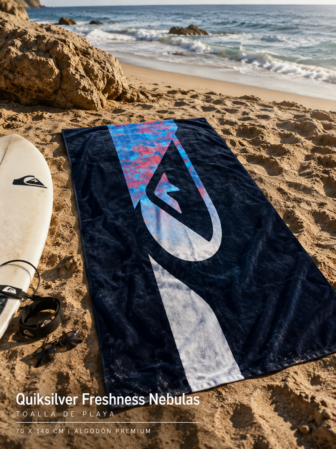Toalla Quiksilver Freshness Nebulas Blue Fade Reflection estilo surf premium sobre arena junto al mar