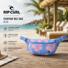 Riñonera Rip Curl Everyday Belt Bag Blue en fotografía editorial propia de THE SURF TOWN en beach club tropical premium con estampado floral, diseño ligero, correa ajustable y estilo surf femenino para playa, viajes y uso diario.