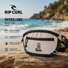 Riñonera Rip Curl Overland Waist Bag Stone en fotografía editorial propia de THE SURF TOWN junto al mar con múltiples compartimentos, diseño ligero y estilo surf outdoor para viajes y uso diario.