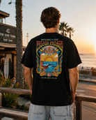 Camiseta Rip Curl hombre negra con diseño surf tropical en paseo marítimo lifestyle premium al atardecer Costa del Sol