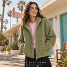 Chaqueta polar Roxy Blurry Cloud Oil Green en motel vintage; imagen editorial propia de surf town